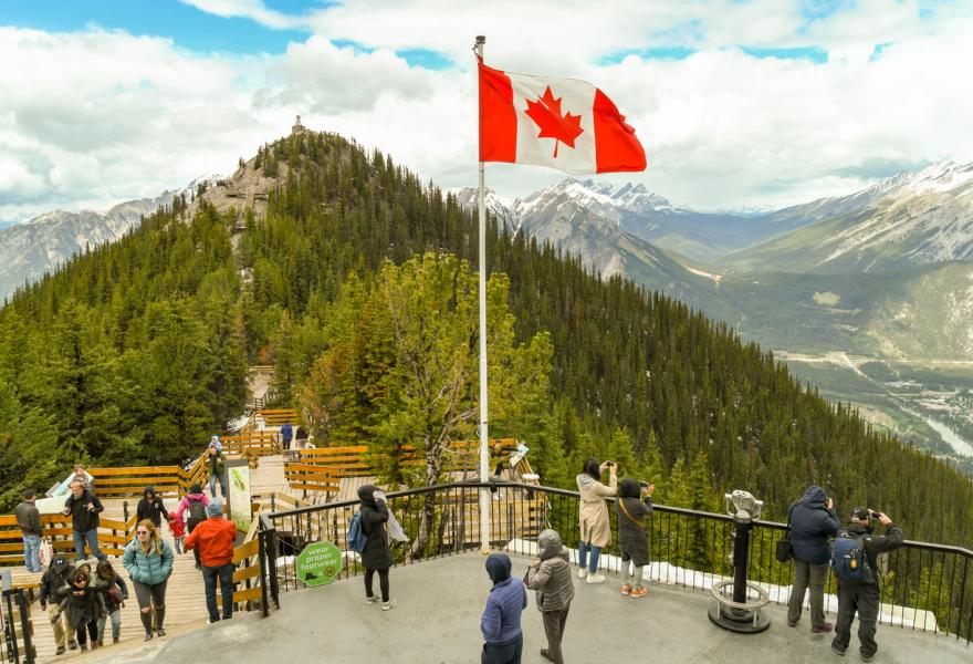 Banff, Alberta, Canada - June 2018: Visitors on the lookout point on the top of Sulphur Mountain in Banff.